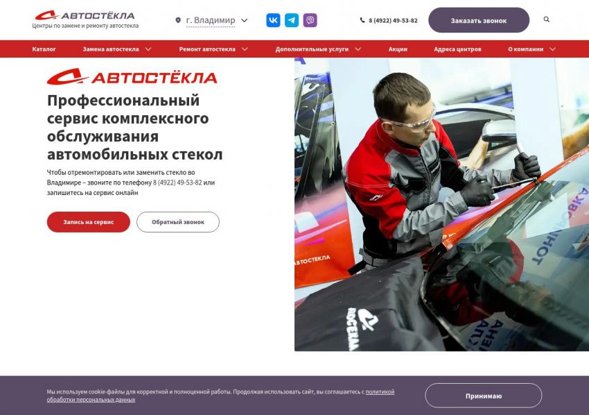 Обледеневшее лобовое стекло автомобиля и водитель со скребком